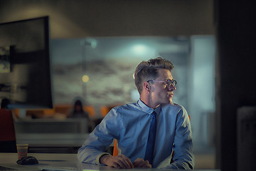 Image showing man working on computer in dark office