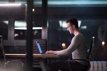 Image showing man working on laptop in dark office