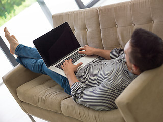 Image showing Man using laptop in living room