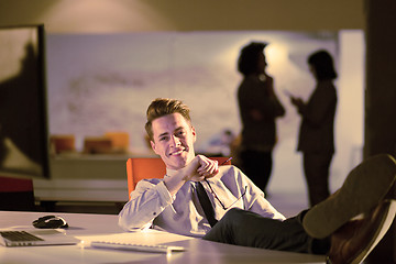 Image showing businessman sitting with legs on desk at office