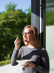 Image showing woman eating breakfast in front of her luxury home villa