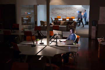 Image showing man working on computer in dark office