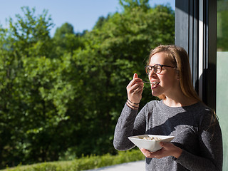 Image showing woman eating breakfast in front of her luxury home villa