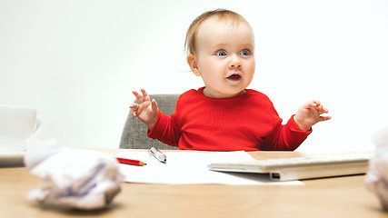 Image showing Happy child baby girl toddler sitting with keyboard of computer isolated on a white background