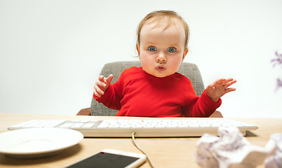 Image showing Happy child baby girl toddler sitting with keyboard of computer isolated on a white background