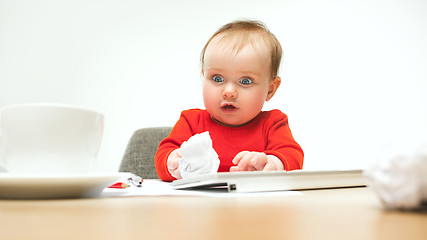 Image showing Happy child baby girl toddler sitting with keyboard of computer isolated on a white background