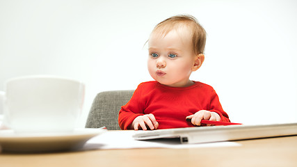 Image showing Happy child baby girl toddler sitting with keyboard of computer isolated on a white background