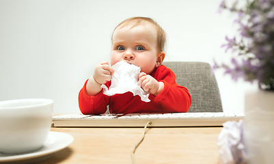 Image showing Happy child baby girl toddler sitting with keyboard of computer isolated on a white background