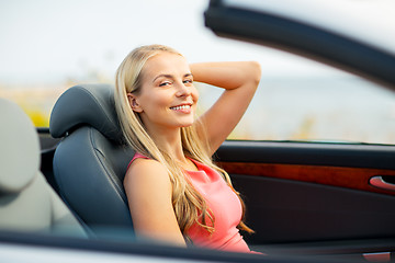 Image showing happy young woman driving convertible car