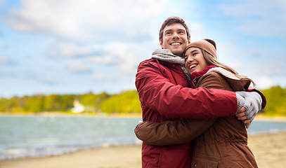 Image showing happy young couple hugging over autumn beach