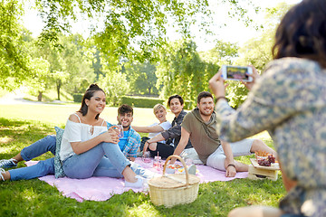 Image showing friends photographing by smartphone at picnic