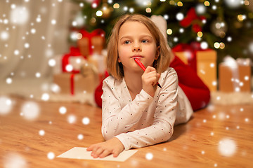 Image showing girl writing christmas wish list at home