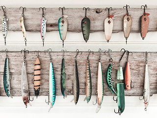 Image showing Colorful fishing baits on a wooden wall