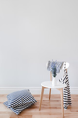 Image showing Interior with chair, striped cushions and clothes