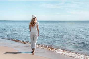 Image showing Young woman in white looking at water