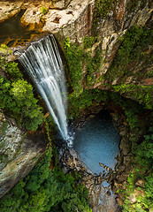 Image showing Waterfall tumbling over the sheer cliffs to idyllic waterhole