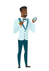 Image showing African-american groom holding a mobile phone.