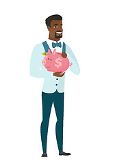 Image showing African-american groom holding a piggy bank.