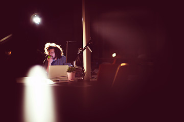 Image showing man working on computer in dark office