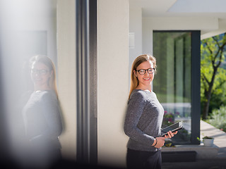 Image showing women using tablet computer in front of luxury home villa