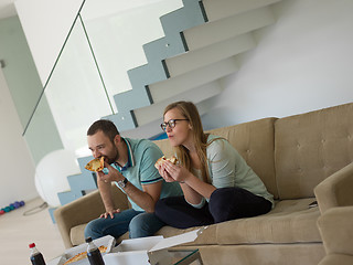Image showing couple eating pizza in their luxury home villa