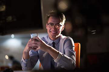 Image showing man using mobile phone in dark office