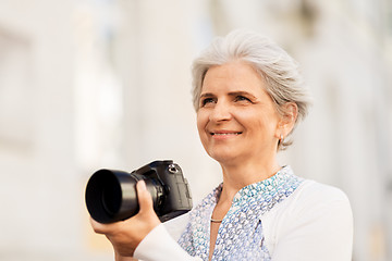 Image showing senior woman photographing by digital camera