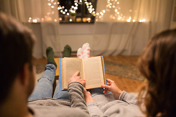 Image showing close up of couple reading book at home