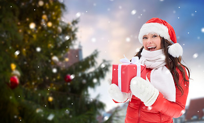 Image showing happy woman with gift over christmas tree