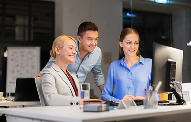 Image showing business team with computer working late at office