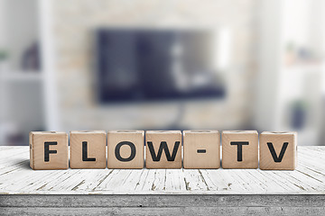 Image showing Flow-tv sign on a wooden table in a living room