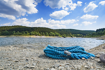 Image showing Blue rope on a pebble beach in the summer