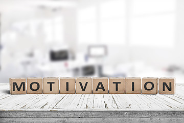 Image showing Motivation sign on a desk in a bright office