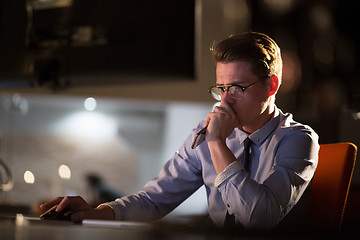 Image showing man working on computer in dark office