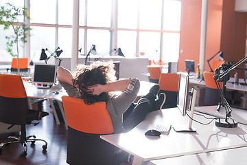 Image showing businessman sitting with legs on desk