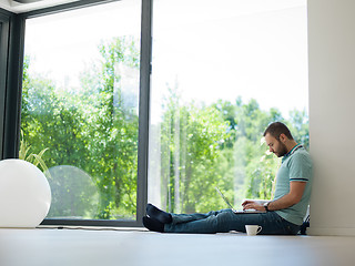Image showing man drinking coffee on the floor enjoying relaxing lifestyle