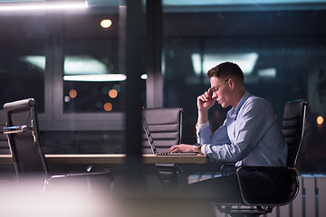 Image showing man working on laptop in dark office