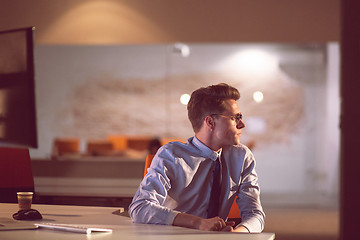 Image showing man working on computer in dark office