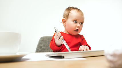 Image showing Happy child baby girl toddler sitting with keyboard of computer isolated on a white background