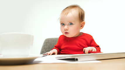 Image showing Happy child baby girl toddler sitting with keyboard of computer isolated on a white background