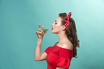 Image showing Beautiful young woman with pinup make-up and hairstyle. Studio shot on white background