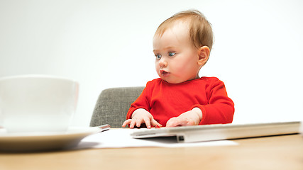 Image showing Happy child baby girl toddler sitting with keyboard of computer isolated on a white background