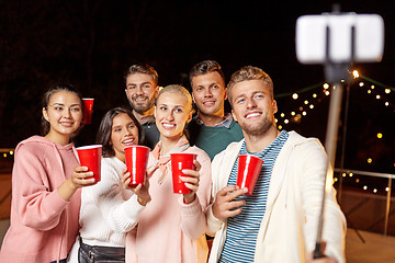 Image showing friends with drinks taking selfie at rooftop party