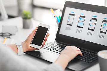 Image showing web designer with smartphone and laptop at office