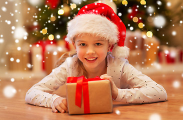 Image showing smiling girl in santa hat with christmas gift