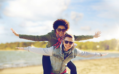 Image showing happy teenage couple in shades having fun on beach