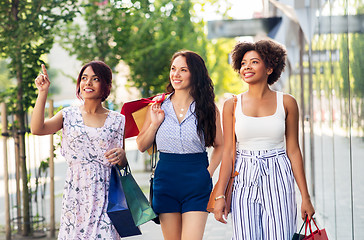 Image showing happy women with shopping bags walking in city