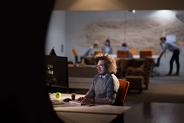 Image showing man working on computer in dark office