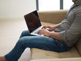 Image showing Man using laptop in living room