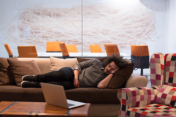 Image showing man sleeping on a sofa  in a creative office